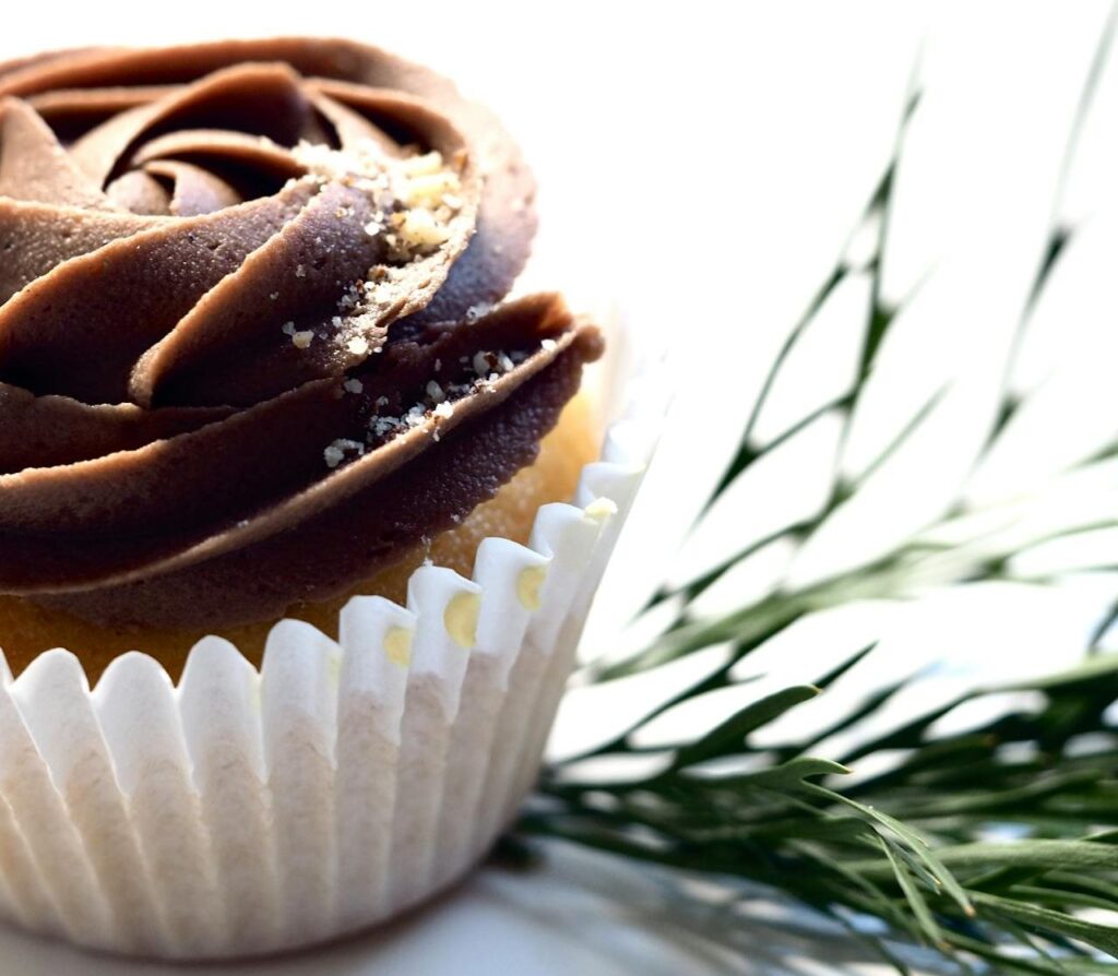 Cupcake au glaçage chocolat avec une rose sur le dessus