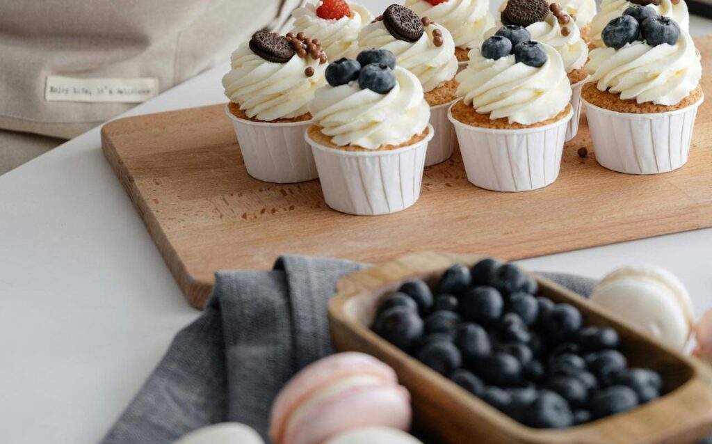 Cupcakes aux myrtilles et crème sur un plateau en bois