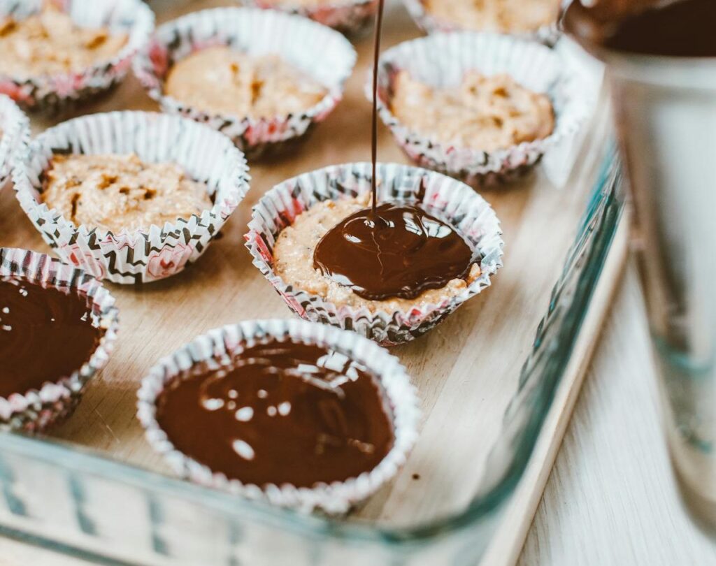 Chocolat fondu versé dans des cupcakes sur un plateau